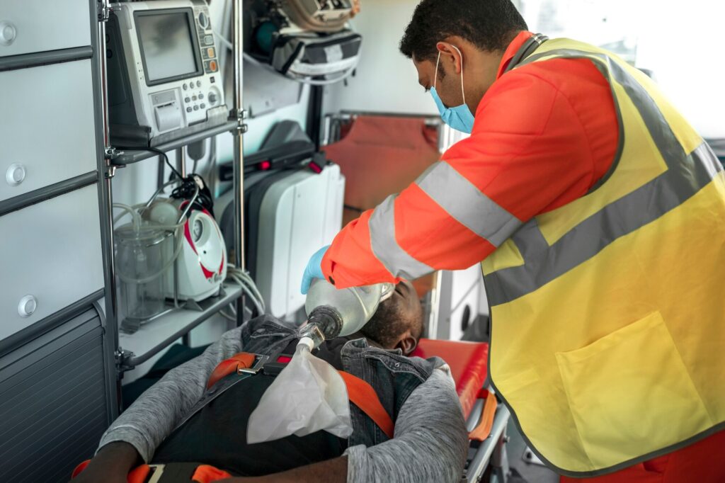 An EMT providing emergency medical care to a patient on a stretcher inside an ambulance. this is the importance of 24/7 emergency services.