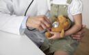 Pediatrician using a stethoscope on a stuffed toy held by a young girl – child-friendly medical examination for Common Childhood Illnesses.